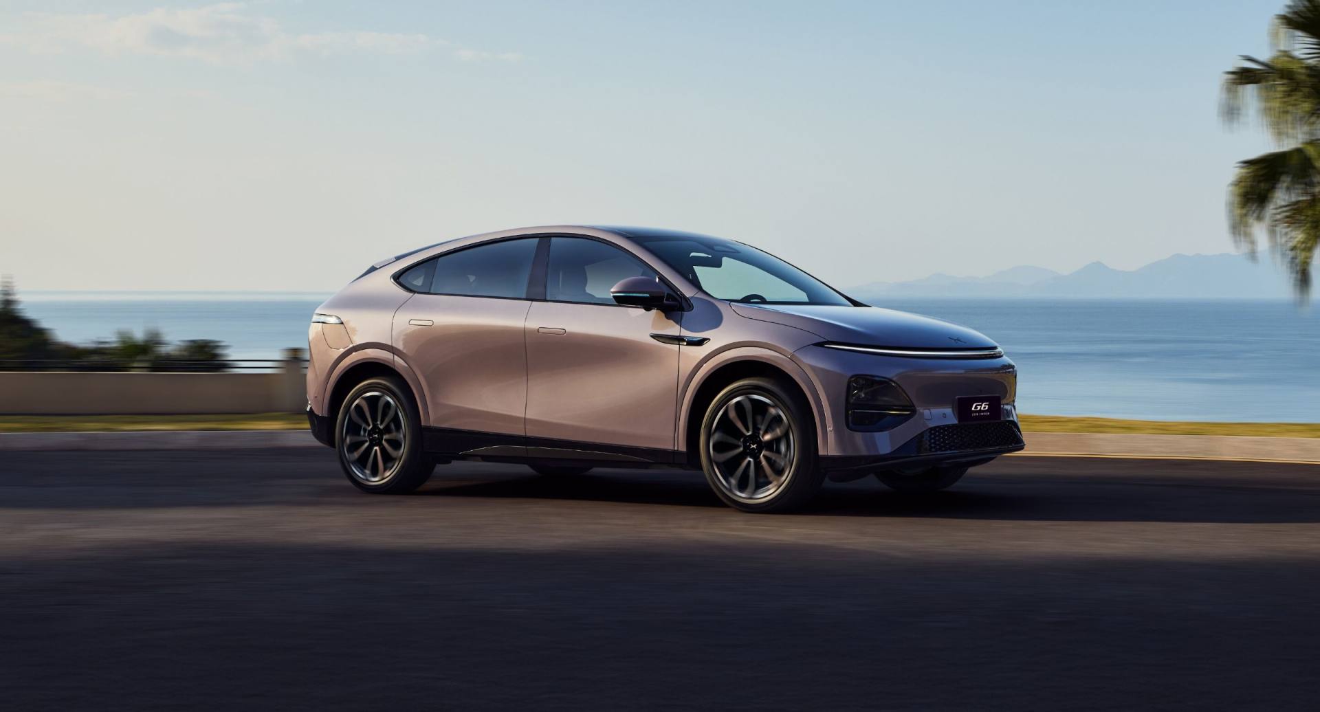Voiture électrique premium en bord de mer au coucher du soleil